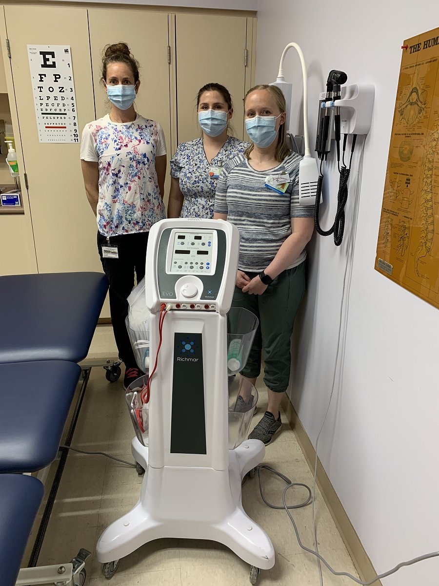 Three employees and an ultrasound machine